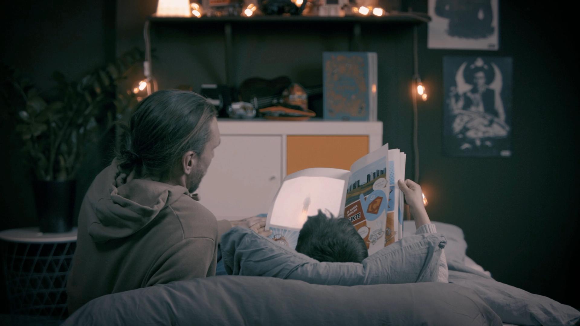 Far og sønn leser et tegneserieblad om kundereiseheltene 
